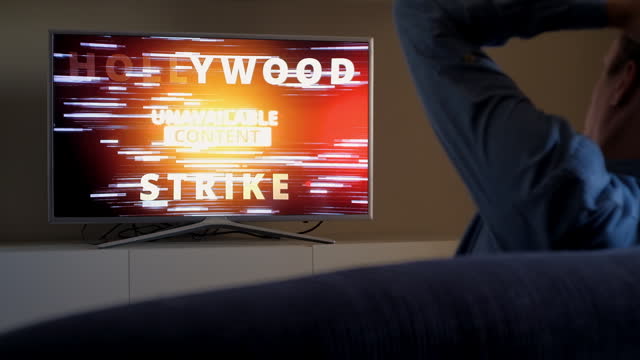 Upset viewer emotionally grabs his head because of Hollywood Strike news on TV