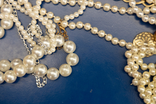 pearl necklace resting on a blue background