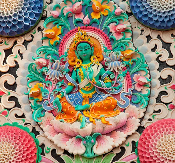 image of the female deity Green Tara, depicted in a butter sculpture on display at a Tibetan temple in India. Butter sculpture is a temporary Tibetan religious art-form, usually made by monks