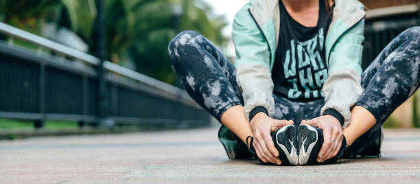 Woman runner relaxing sitting on the floor after training stock photo
