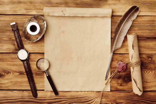 istock Old paper on brown wood background with feather 1558042028