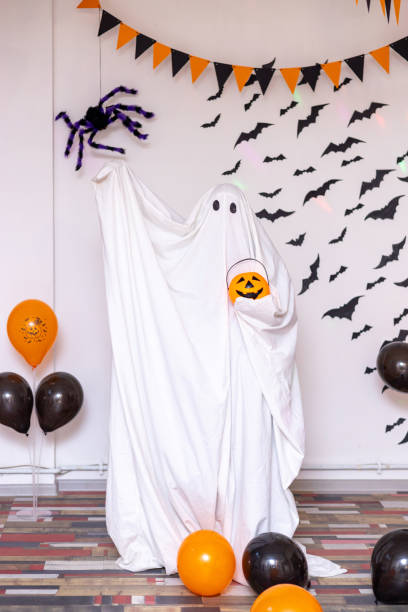 istock A man in a ghost costume from a sheet on a Halloween holiday. 1558072854
