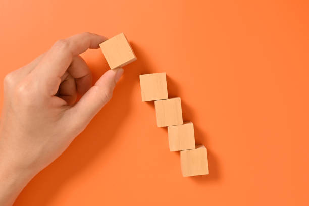 istock Hand with wooden cubes mock up on abstract background, Copy space, Wooden blocks with copy space for text or symbols, Background with copy space 1558085875