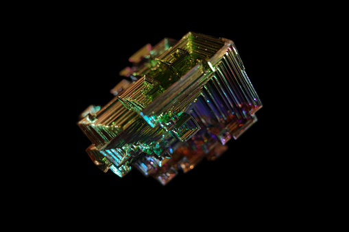 Bismuth crystal on black background close up