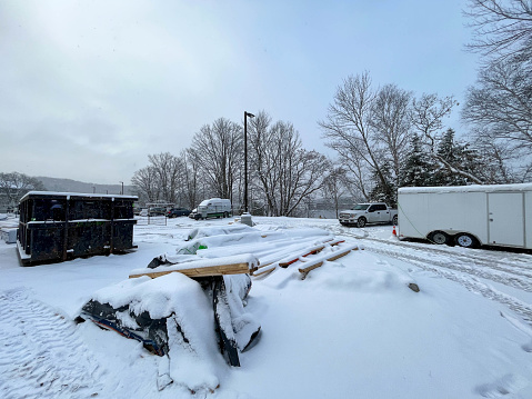 Building and parking area with woods and vehicles covered by snow in winter in Canada.
