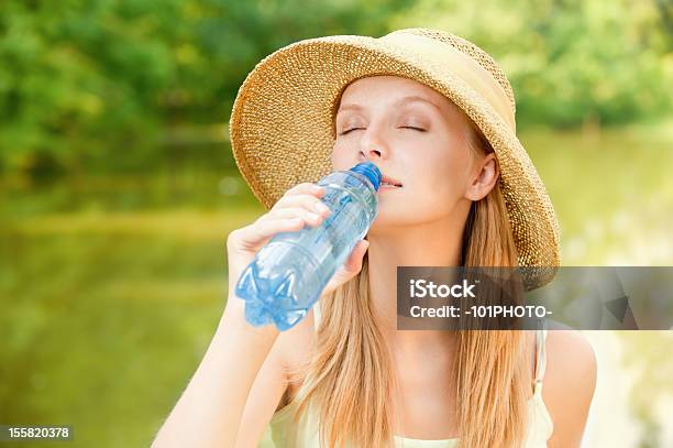 Girl In Straw Hat Bebidas De Agua Foto de stock y más banco de imágenes de Beber - Beber, Botella, Calor