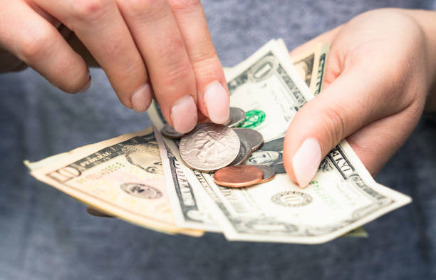 Close-up as a woman checks US banknotes and coins.