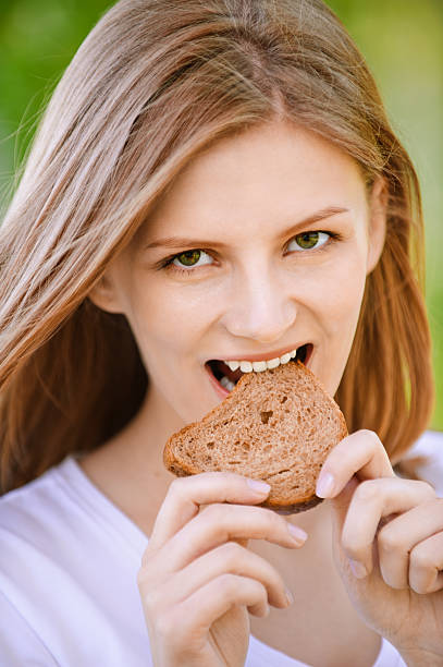 istock Woman bites piece of bread 155821050