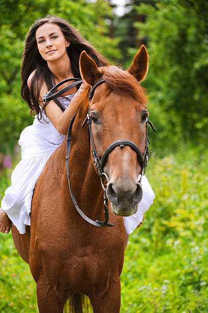 istock young brunette woman rides a horse 155821837