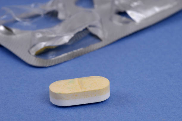 Medicine shortage concept with a pill and an empty blister pack close up on a blue background