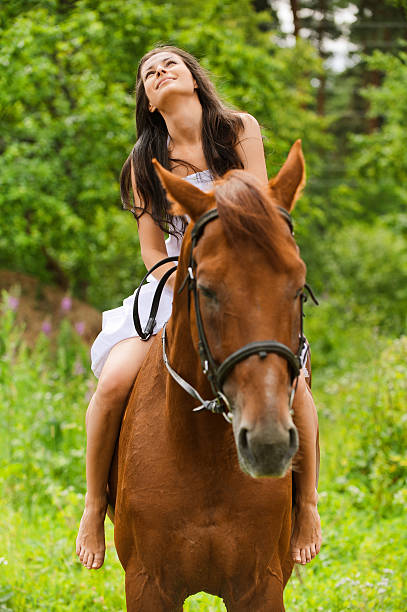 istock young smiling woman riding horse 155822700