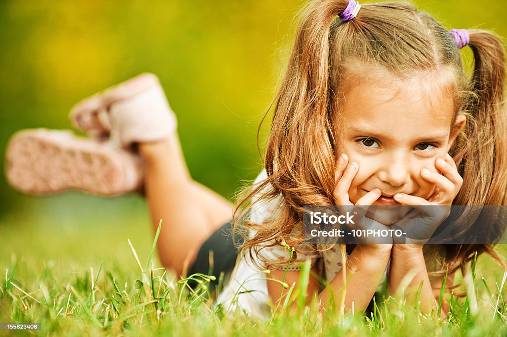Encantadores Retrato de niña caer sobre hierba - Foto de stock de Acostado libre de derechos