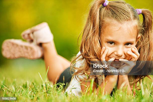 Encantadores Retrato De Niña Caer Sobre Hierba Foto de stock y más banco de imágenes de Acostado - Acostado, Actividad de fin de semana, Actividades recreativas