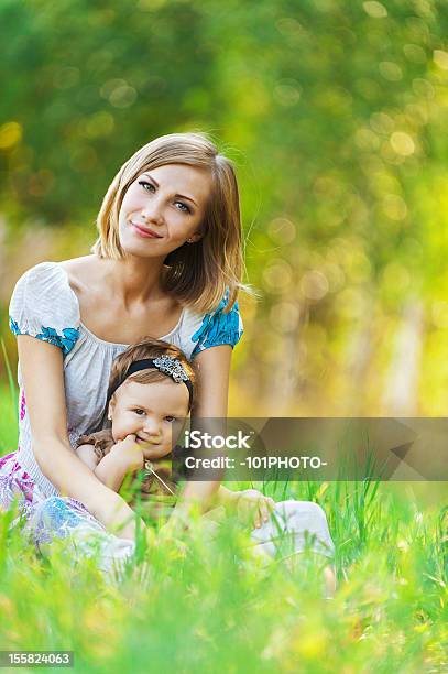 Madre Figlia Seduta Erba - Fotografie stock e altre immagini di Abbracciare una persona - Abbracciare una persona, Accudire, Adulto
