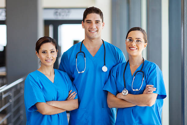 young hospital workers in scrubs group of young hospital workers in scrubs medical scrubs stock pictures, royalty-free photos & images