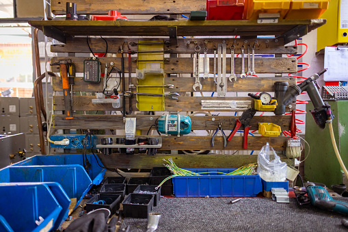 Inside of a workshop, tools are on the wall.