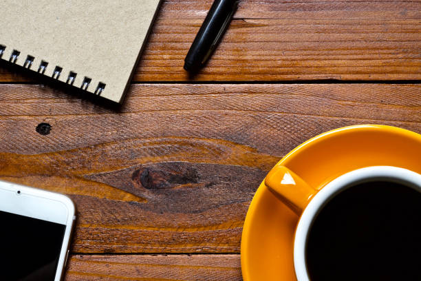 istock Coffee cup hot and notebook pen in the morning 1558257216