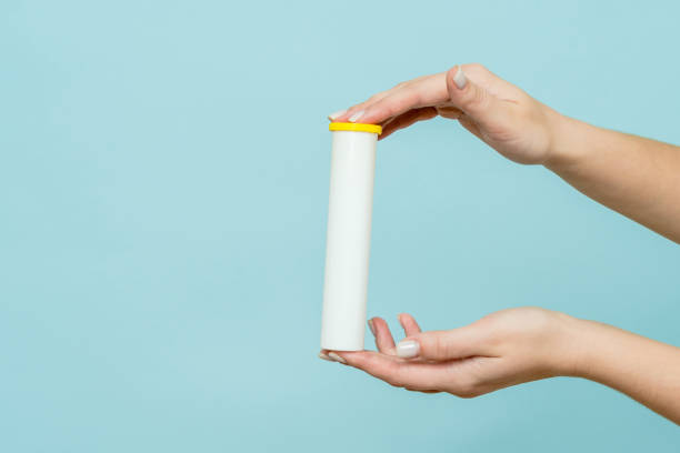 istock Tube for vitamins, pills in hand. Packaging. Mockup 1558259440