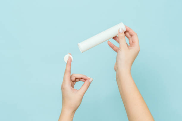 istock Packaging for vitamins, pills with tablet in hand. White tube. Mockup 1558259454