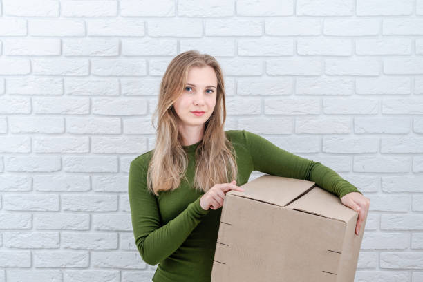 istock Attractive woman holding parcel box. Delivering a parcel 1558259721