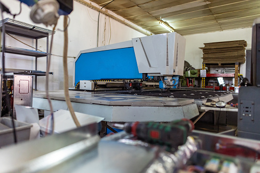 Close-up shot of a laser cutting machine in operation inside a factory.