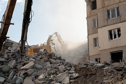 Demolishing process of residential building. Bulldozer dismantle the rubble of a house.