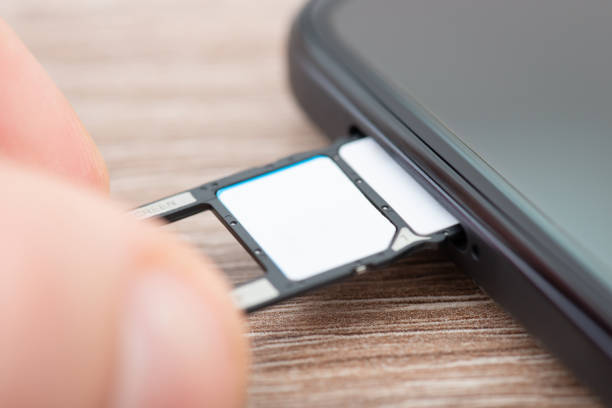 istock Inserting cards tray with two sim card into the phone, close up 1558284133