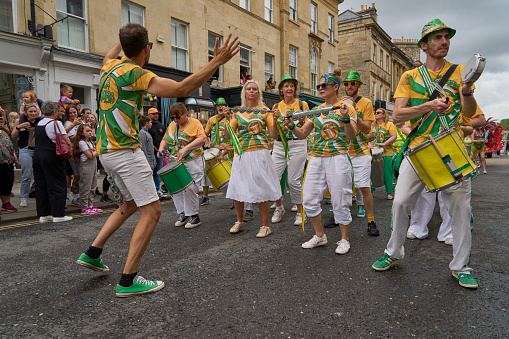 Bath, England, United Kingdom - 8 July 2023: Dancers and musicians dressed in ornate costumes parade through the streets of Bath in the annual carnival.