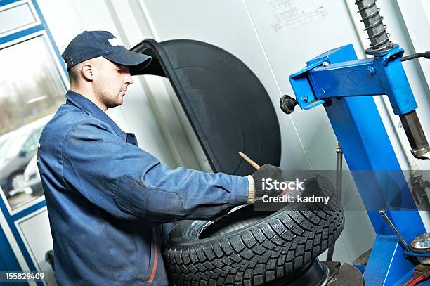 Repairman Mechanic Lubricating Car Tyre Stock Photo - Download Image Now - Installing, Tire - Vehicle Part, Auto Repair Shop