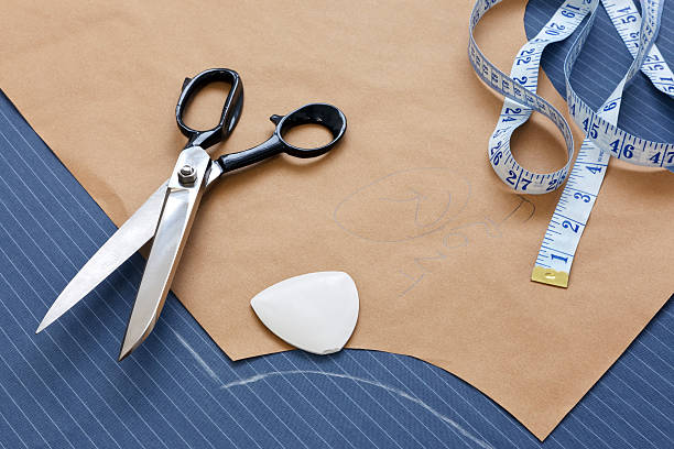 Suit template still life Still life photo of a suit pattern template with tape measure, chalk and scissors. clothing pattern stock pictures, royalty-free photos & images