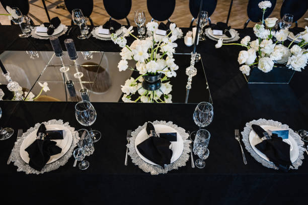 istock Serving, setting table. Plate and glass, stack, wineglass, luxury black rich decor. Wedding set up, dinner table reception. Birthday, baptism, event. Closeup details interior. Top view. 1558297173