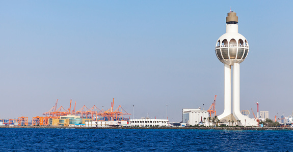 Skyline of Jeddah Islamic Seaport with white traffic control tower, seaside view. Saudi Arabia