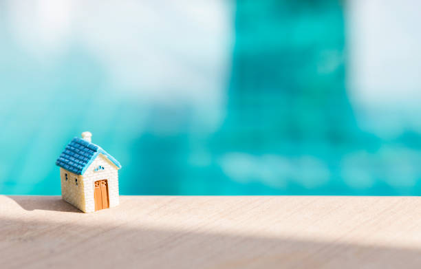 istock Miniature house on swimming pool edge with morning day light 1558304347