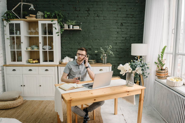 istock Communication, technology concept. Trader talk on phone, investor broker analyze market. Serious man working, learning on laptop in home office. Freelance.  Marketing, design. Trading cryptocurrency. 1558310811