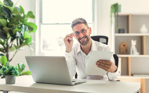 istock Mature business man using laptop computer in office. 1558325554