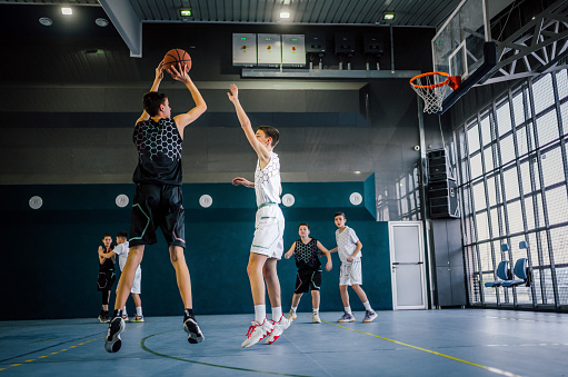 Three basketball player players in action on dark background