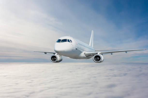 istock Modern white passenger jetliner flying in the sky above the clouds 1558354971