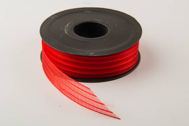 istock Large spool of  ribbon on white background 1558357575