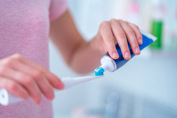 istock Brushing teeth using ultrasonic electric toothbrush and toothpaste in bathroom at home. Oral hygiene, dental and gum health 1558372491