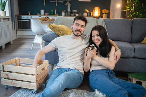 Young Caucasian couple at home with their pets, guinea pigs