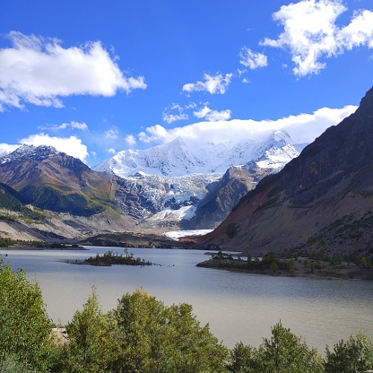 A picturesque landscape with a tranquil lake surrounded by snow-covered mountains and forests