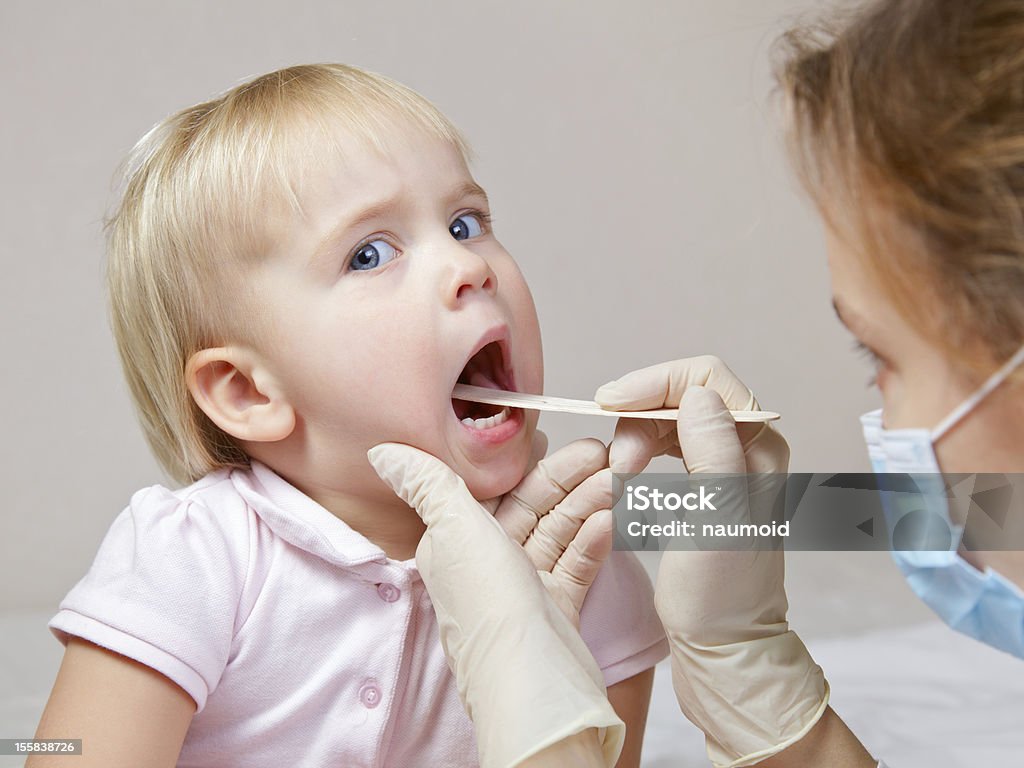 Throat check Pediatrician examining little girl's throat with tongue depressor Tongue Depressor Stock Photo