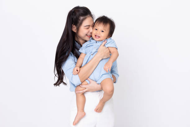 asian mom hold baby smile and kissing on baby cheek happiness moment together isolated on white background. healthy mother and baby boy smile and laughing spending time together positive and cheerful. - love growth time of day cheerful imagens e fotografias de stock