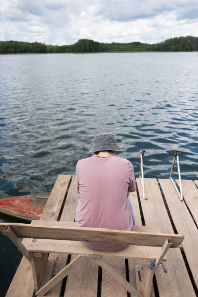 istock Young boy on a pier near lake 1558427975