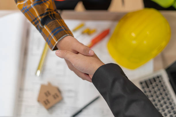 istock Construction worker team hands shaking greeting start up plan new project contract in office center at construction site, industry ,architecture, partner, teamwork, agreement, property, contacts. 1558428911