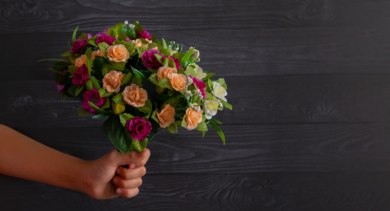 Child holding a bouquet of flowers in the hand