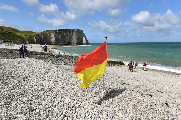 flag on the beach, étretat, france. - white cliffs imagens e fotografias de stock