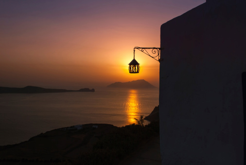 Milos sunset through a lantern - concept of sustainability - solar energy