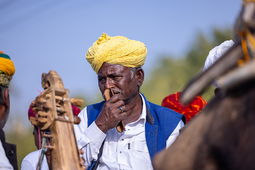 Bikaner, Rajasthan, India - January 2023: Camel Festival, Portrait of an rajasthani male with moustache, colorful turban wearing traditional colorful rajasthani dress. Rajput male of bikaner.