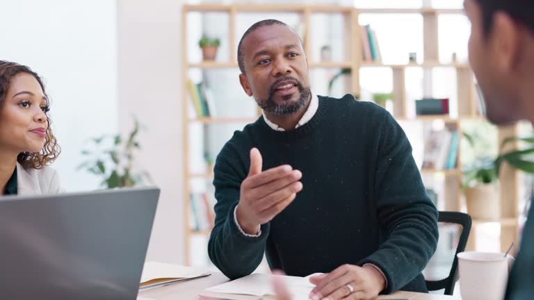 Meeting, planning and a senior business black man talking to his team for coaching as a mentor in a workshop. Management, strategy and collaboration with a mature male CEO chatting in a staff seminar